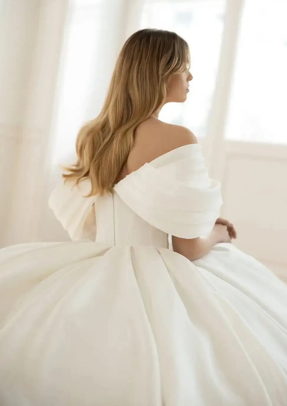 Introducing the Robe Elia - the perfect addition to your special day! This wedding dress features an elegant sweetheart neckline, delicate bow accents, and a romantic off the shoulder design. The A-line silhouette flatters every figure, while the ruched bodice adds a touch of sophistication.