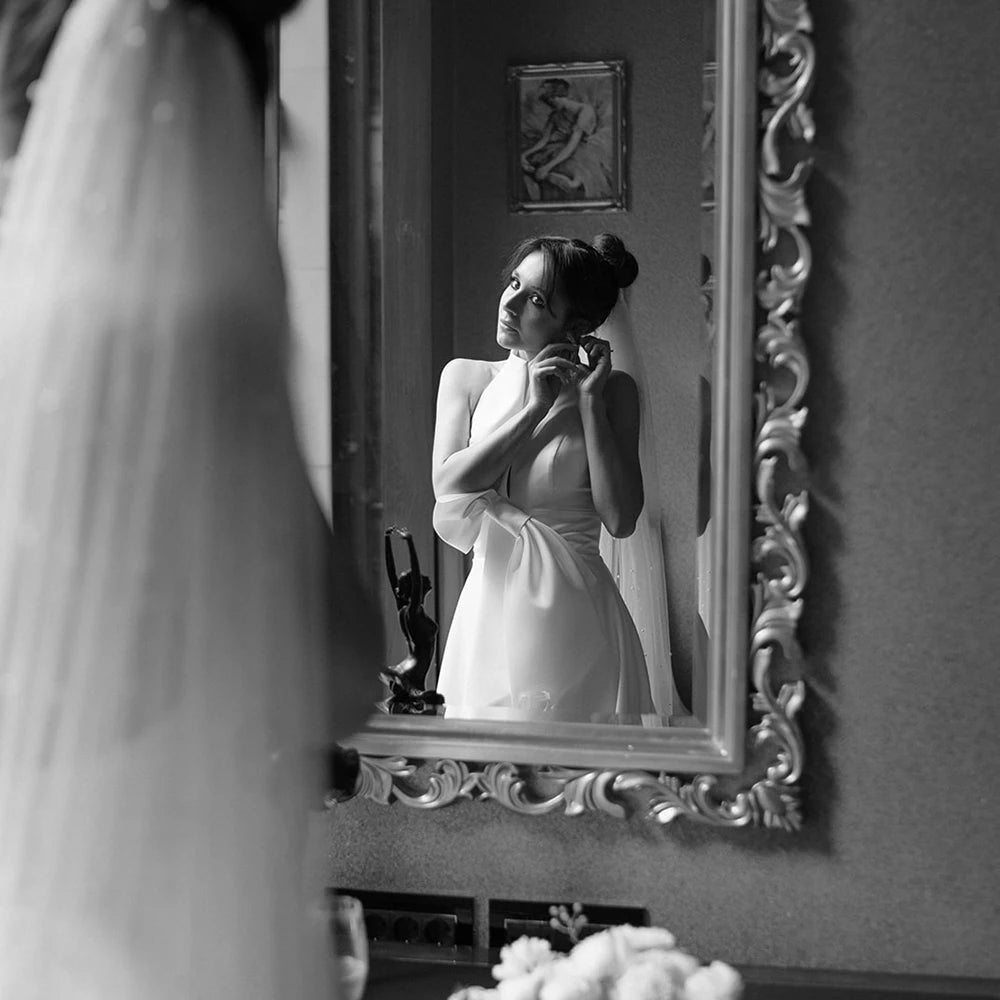 Feel like royalty in this Robe Oceane wedding dress. Handcrafted with luxurious satin, this halter high neck dress features a minimalist design for an effortlessly sophisticated look. The backless design with a large bow trailing the A-line silhouette is a timeless classic that will make you look and feel like a beautiful bride. Custom made and available in big sizes, make your special day even more special with this exquisite minimalistic yet sexy gown.