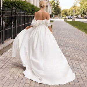 Robe Amabel is an exquisite option for brides seeking an effortless and elegant look. Crafted from slinky fabric, it features an off-the-shoulder design, a mermaid silhouette with detachable train, a sweetheart neckline, and a backless side slit for an opulent and glamorous appeal. This luxurious robe will add an understated sophistication to any wedding look.
