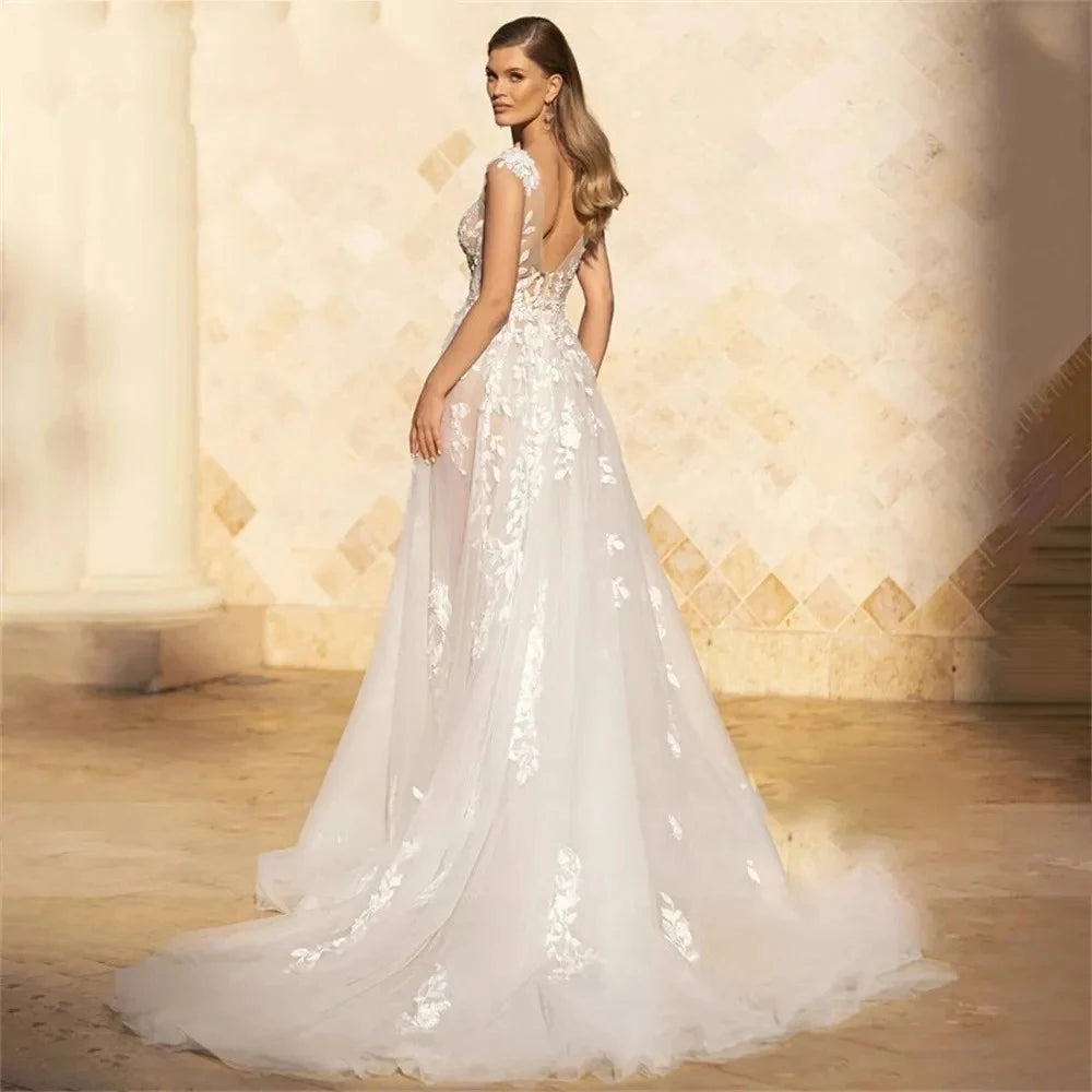 Indulge in luxury with the Robe Dior - a stunning bridal dress featuring cap sleeves and a backless design, all adorned with intricate floral and leaf lace detailing. The A-line silhouette and tulle fabric make this dress both elegant and comfortable, making it the perfect choice for your special day.