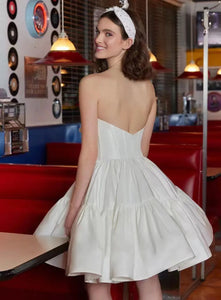 Get ready to stun on your wedding day with the Robe Sherry! This mini wedding dress is perfect for the modern bride, featuring a sweetheart neckline, detachable sleeves, and a boning corset for a flattering fit. Made with luxurious satin, this bridal gown will have you walking down the aisle in style.