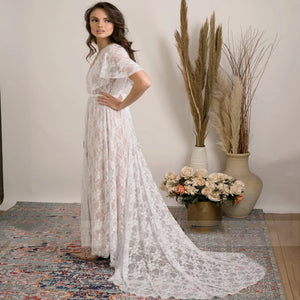Feel like a boho princess in the Dress Vanille! Perfect for beach weddings, this dress features a V-neck, flutter sleeves, and a sheer back with delicate lace details. The high split adds a touch of elegance to this whimsical and playful design. Say 'I do' in style!