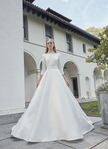The Robe Magdalene is an elegant, a-line bridal gown fit for a princess. Its timeless design and flowing silhouette exude sophistication and grace. With its stunning appearance, this gown is perfect for any bride looking to make a statement on her special day.