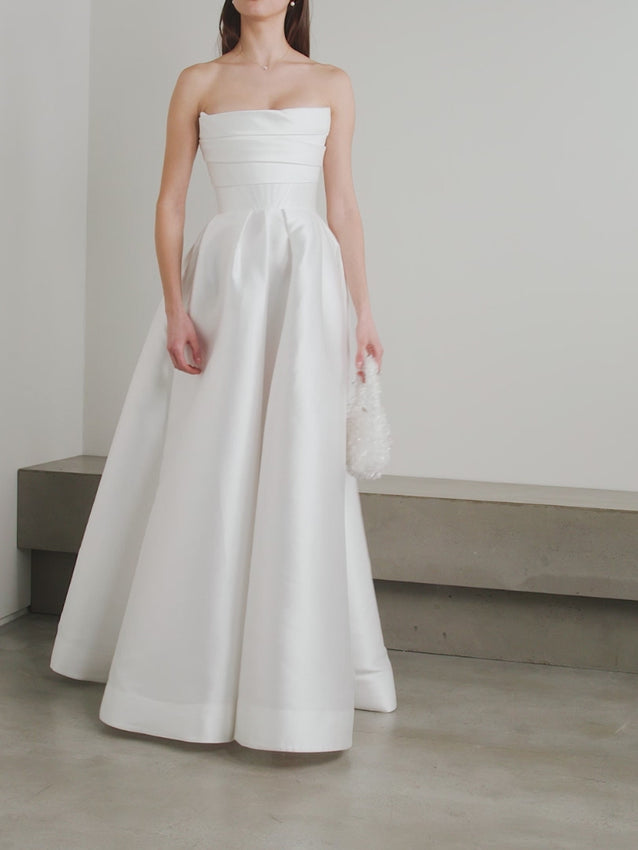 'Isobel' gown is such an elegant choice for your special day. Crafted from white satin-faille with a lustrous finish, it has the signature sculptural bodice and a full skirt with pleats that add structure and volume.
