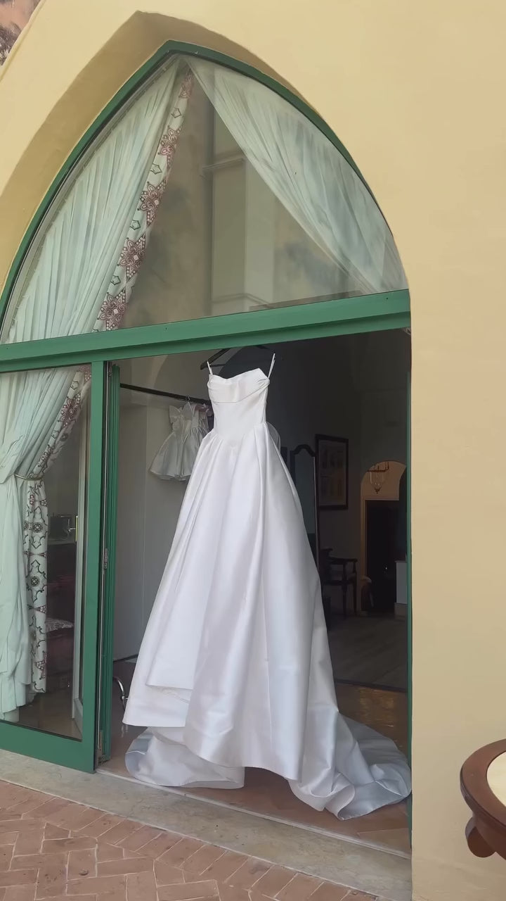 Be the bride of everyone's dreams with the Eva Gown. This chic and simple white satin dress exudes elegance and romance, making you feel like a fairytale princess on your special day. Say "I do" to this dreamy and stylish gown.