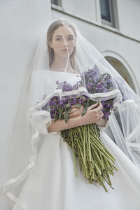 The Robe Magdalene is an elegant, a-line bridal gown fit for a princess. Its timeless design and flowing silhouette exude sophistication and grace. With its stunning appearance, this gown is perfect for any bride looking to make a statement on her special day.
