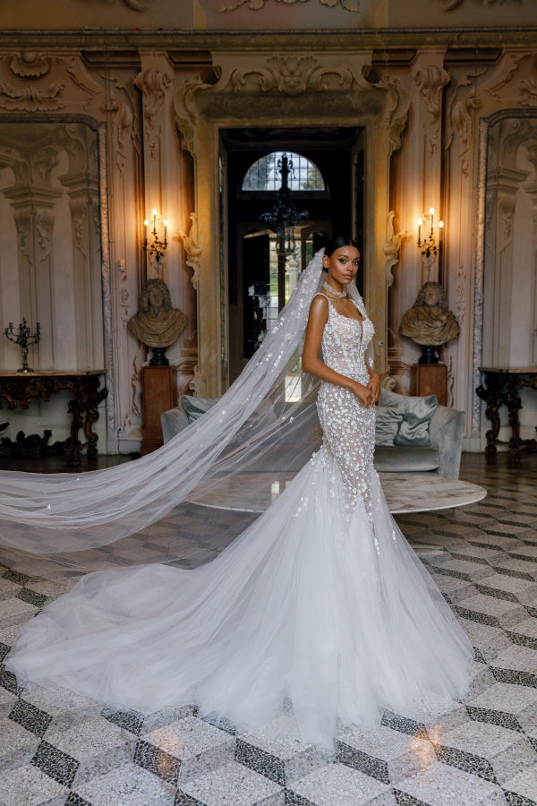 Elevate your bridal look with the Michelle Gown. The long mermaid train adds a touch of elegance to this stunning dress, making you feel like a true princess on your special day. With its perfect fit and classic design, this gown is sure to make you feel confident and beautiful.