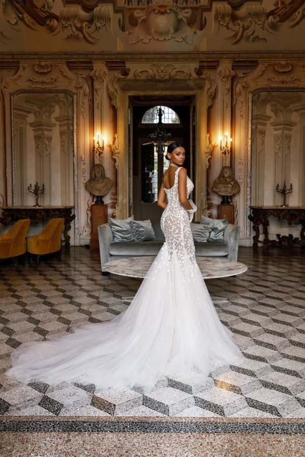 Elevate your bridal look with the Michelle Gown. The long mermaid train adds a touch of elegance to this stunning dress, making you feel like a true princess on your special day. With its perfect fit and classic design, this gown is sure to make you feel confident and beautiful.